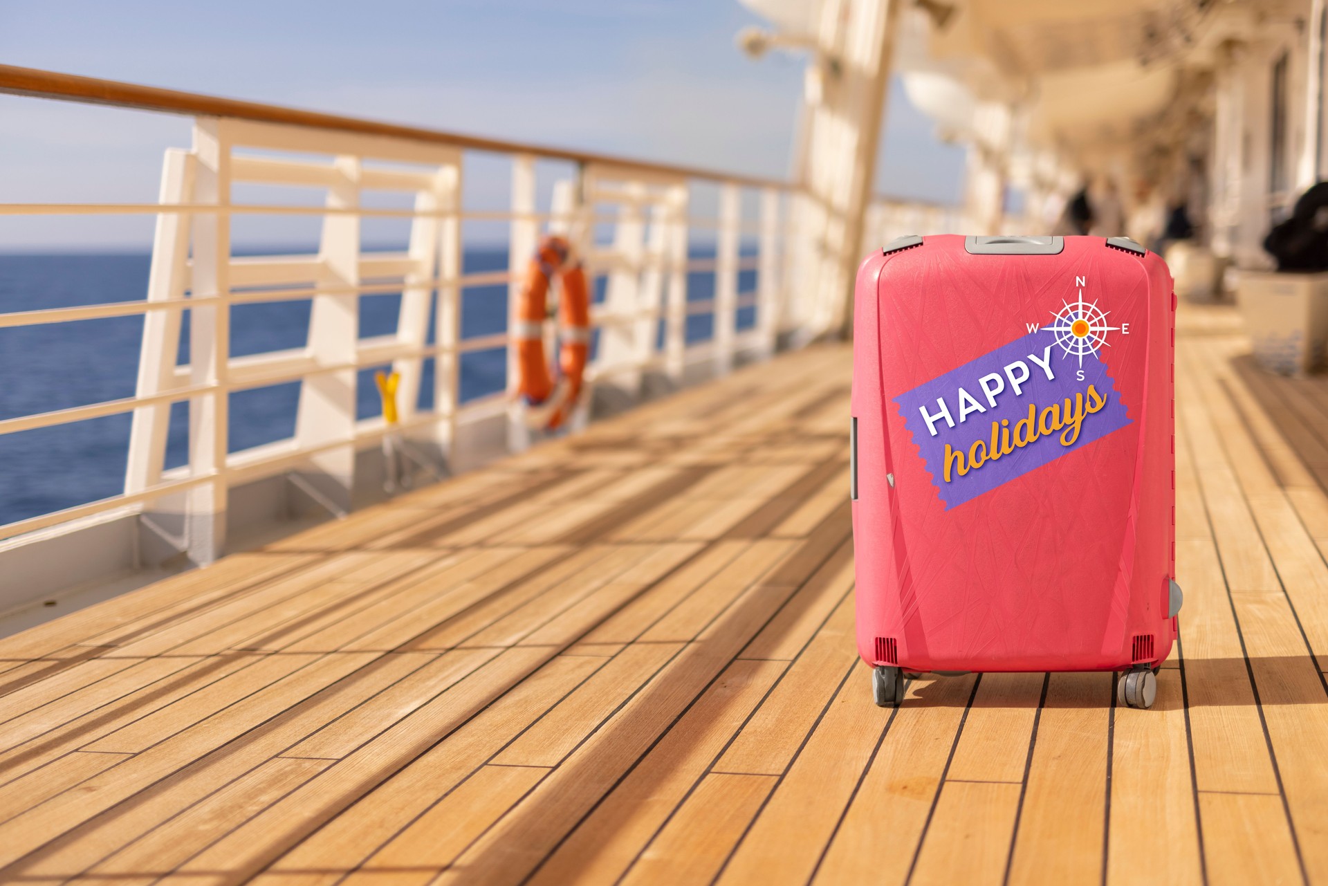 Passenger suitcase standing on the wooden deck of an cruise ship at holidays